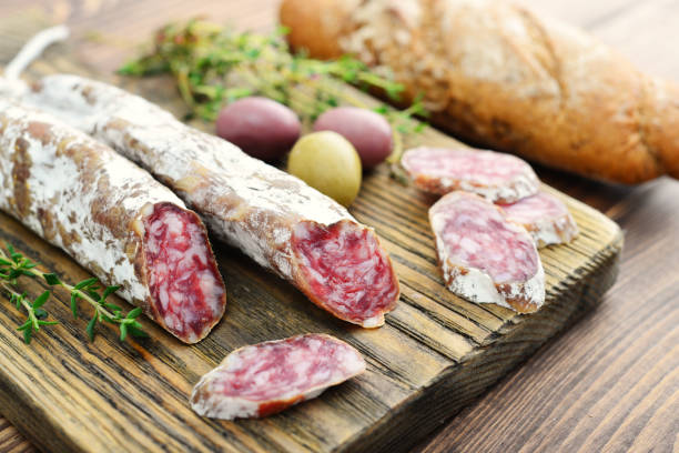 Spanish moldy salami Spanish moldy salami on cutting board with olives and bread over wooden background spanish fork utah stock pictures, royalty-free photos & images