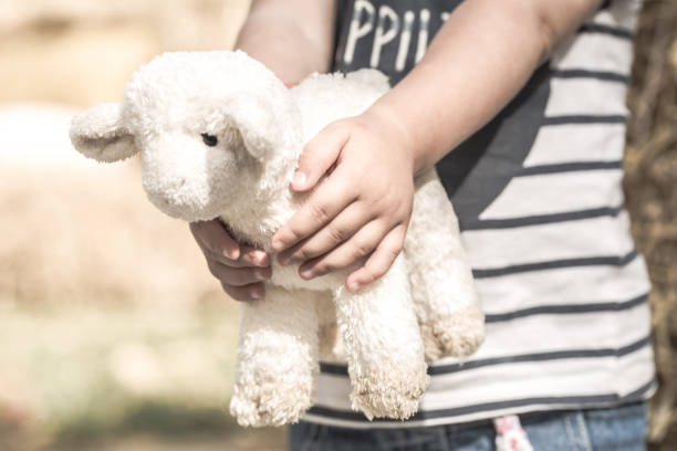 istock little girl holding a toy sheep 854017726