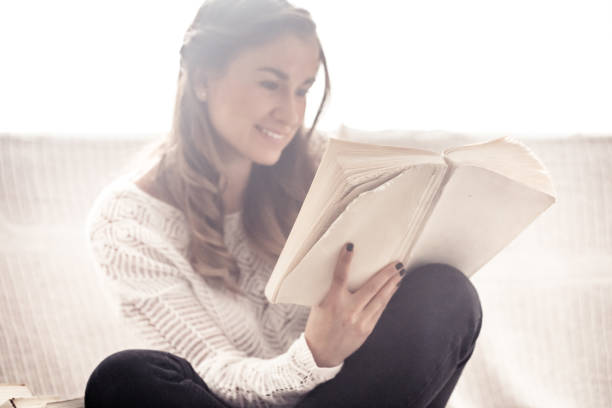 istock girl reading a book closeup on the sofa 854018290