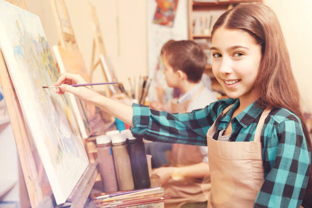 istock Smiling girl with painting brush looking into camera 854026156