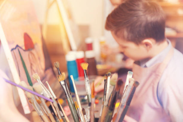 istock Side view on teenage boy in painting class 854026896