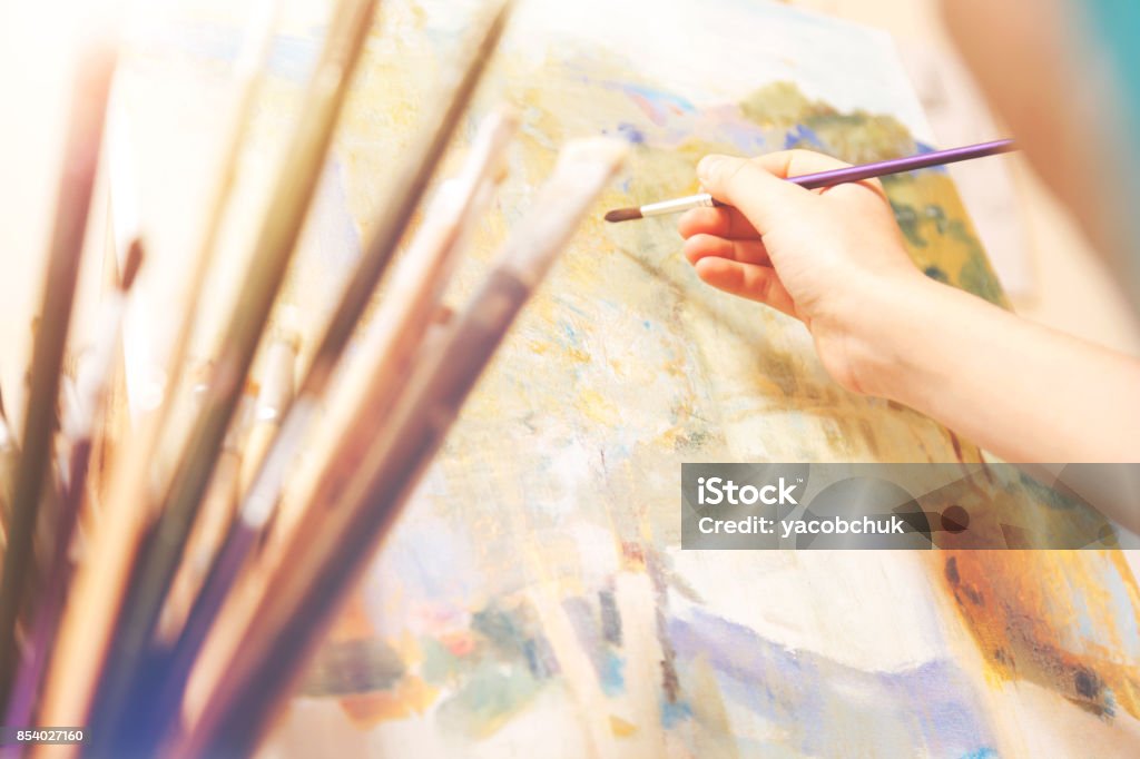 Close up of hand with brush working on abstract picture Creativity has no boundaries. Selective focus on a hand of an artist holding a painting brush and creating a new abstract masterpiece on an art canvas. Artist's Palette Stock Photo