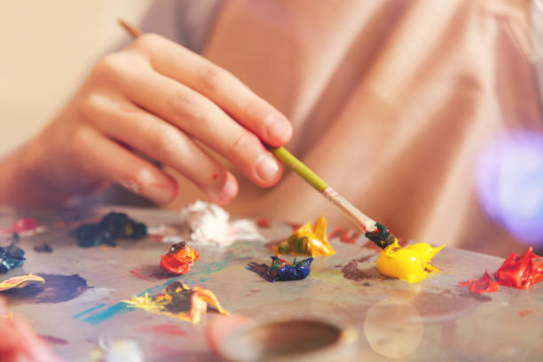 крупным планом ребенка смешивания масляных красок на палитре - entertainment school art studio painter стоковые фото и изображения