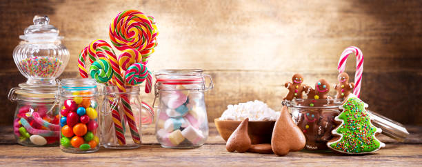 Colorful candies, lollipops, marshmallows and gingerbread cookies  in a glass jars stock photo