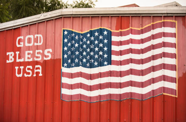 Dallas: God Bless America and American flag painted on the side of a barn in Dallas Texas USA.