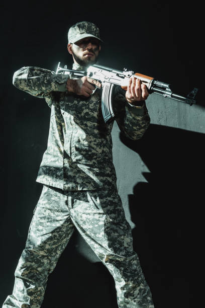 istock soldier in military uniform with rifle 854037982