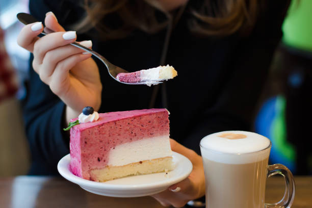 istock Young beautiful woman drinks coffee latte with foam on the table cake 854043772