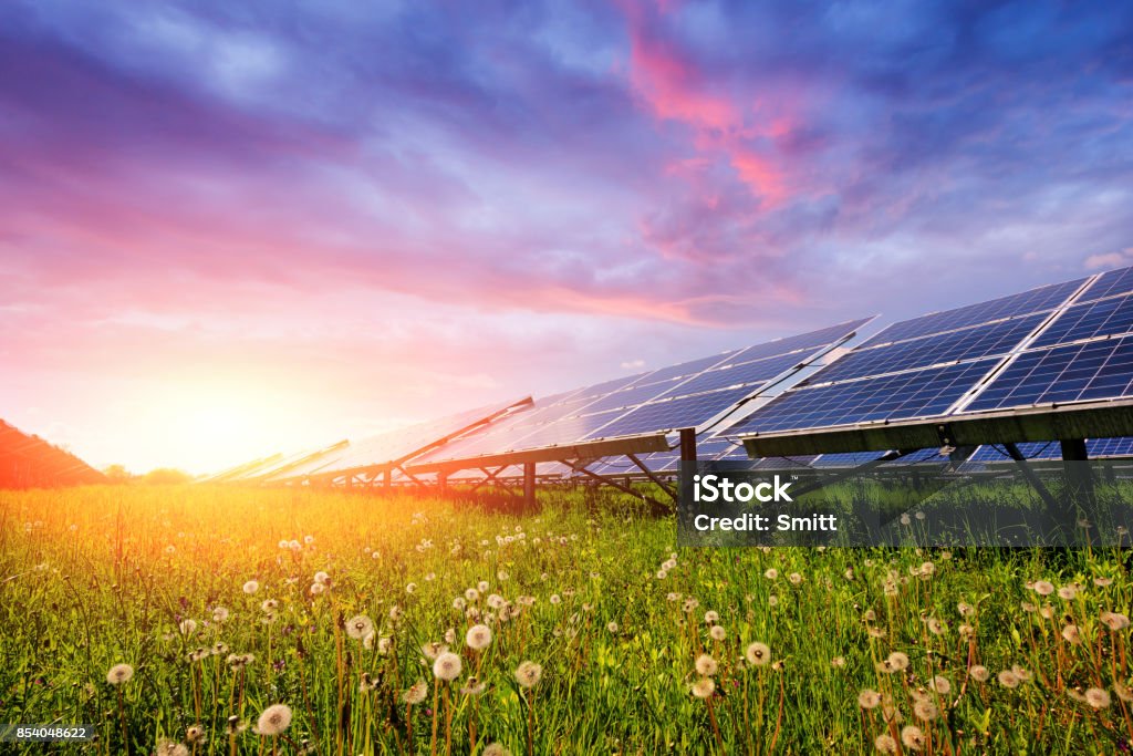 Solar panel on blue sky background Solar panel on blue sky background. Green grass and cloudy sky. Alternative energy concept Solar Panel Stock Photo