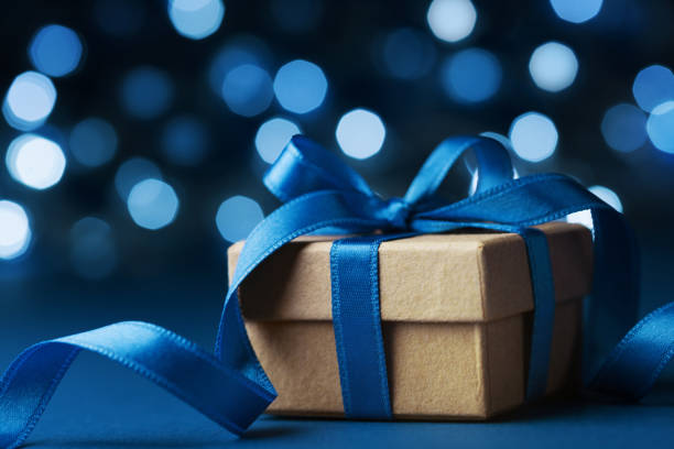istock Christmas gift box or present against blue bokeh background. Holiday greeting card. 854048830
