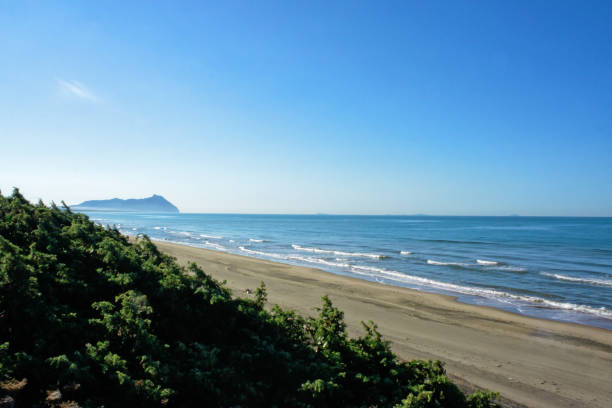 View of the beach of Sabaudia - Italy Beach of Sabaudia with blue sky and Cape Circeo sabaudia stock pictures, royalty-free photos & images
