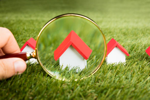 istock Magnifying Glass Inspecting A Model House 854059784