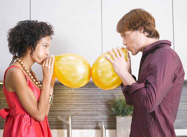 Couple blowing up balloons  inflating stock pictures, royalty-free photos & images