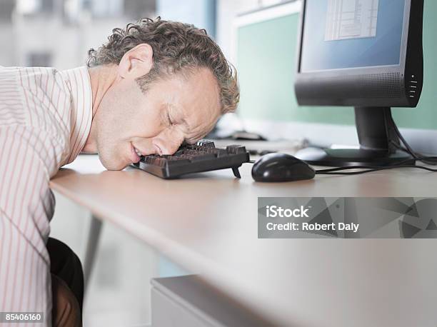 Uomo Daffari Che Dorme Sulla Tastiera Del Computer - Fotografie stock e altre immagini di Dormire