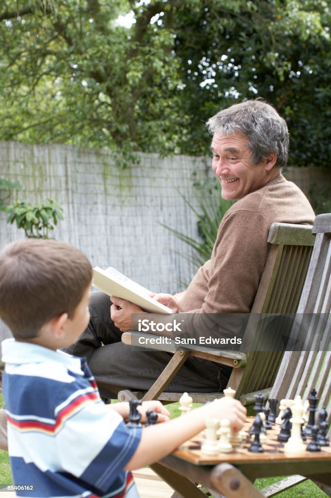 Junge spielt Schach im Garten - Lizenzfrei 55-59 Jahre Stock-Foto