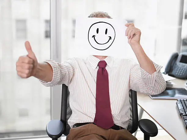 Photo of Businessman holding picture of happy face