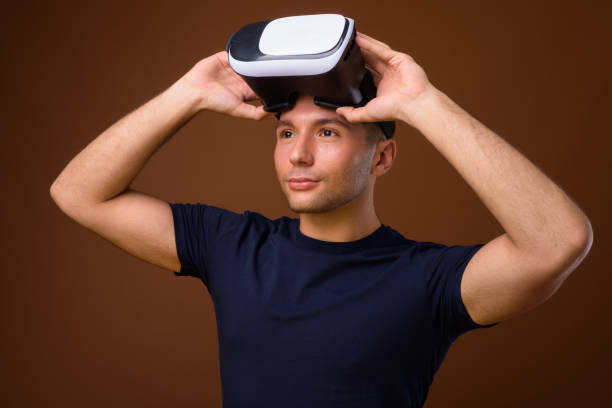 istock Studio shot of young handsome man using virtual reality headset against colored background 854062104