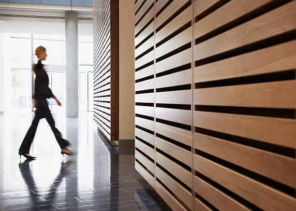 mujer de negocios caminando en el pasillo - entrance hall indoors wall corridor fotografías e imágenes de stock