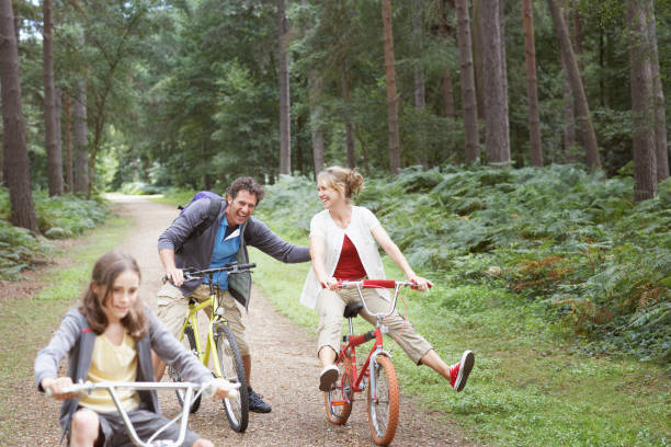 familie reiten fahrräder im wald - child discovery outdoors playing stock-fotos und bilder