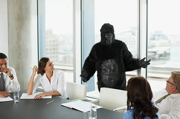 Photo of Gorilla and businesspeople having meeting in conference room