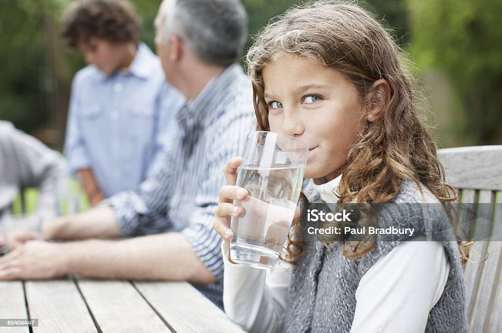 Girl drinking water at picnic table  Drinking Water Stock Photo