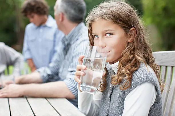 Photo of Girl drinking water at picnic table