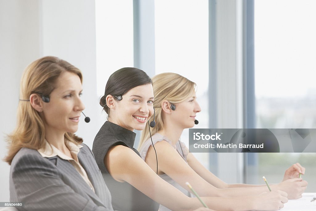 Businesswomen a falar sobre os auscultadores com microfone - Royalty-free Centro de Chamadas Telefónicas Foto de stock
