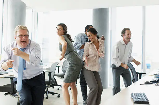 Photo of Businesspeople dancing in office