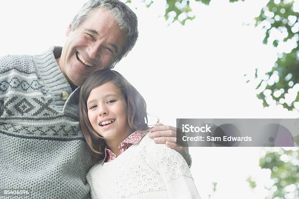 Abuelo Abrazándose Granddaughter Foto de stock y más banco de imágenes de 10-11 años - 10-11 años, 55-59 años, Abrazar