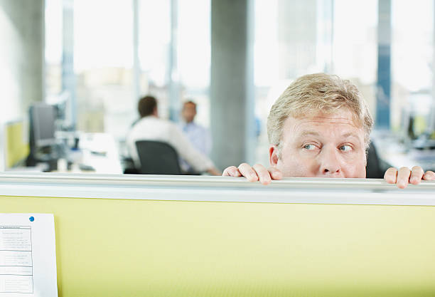 empresário peering com cubículos parede - white collar worker fear businessman business imagens e fotografias de stock