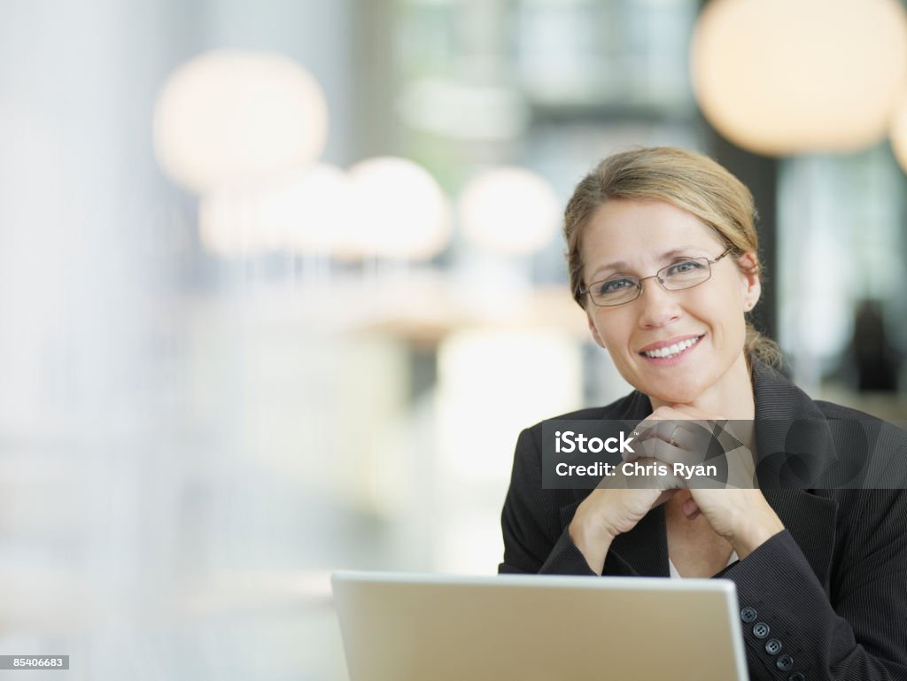 Businesswoman sitting at desk  Businesswoman Stock Photo