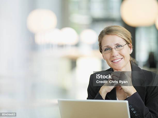 Businesswoman Sitting At Desk Stock Photo - Download Image Now - Businesswoman, Women, Office