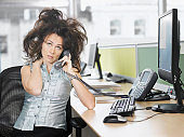 Frazzled businesswoman talking on telephone