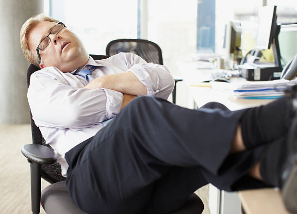 geschäftsmann schlafen mit beine hoch auf dem schreibtisch - asleep on the job stock-fotos und bilder
