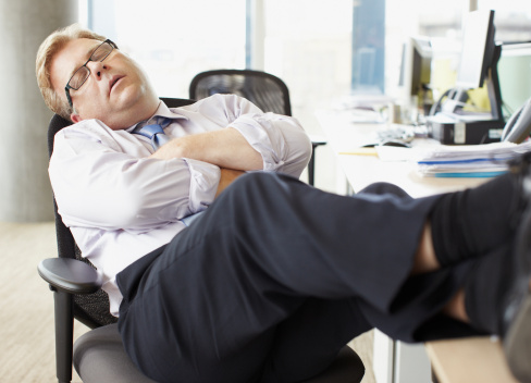 Empresario durmiendo con patas arriba en escritorio photo