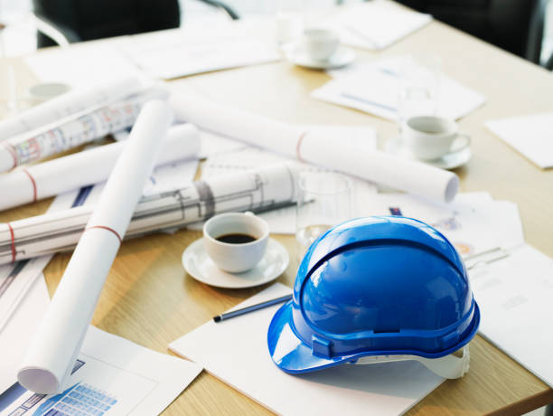 Table with hard-hat and blueprints  architect office stock pictures, royalty-free photos & images