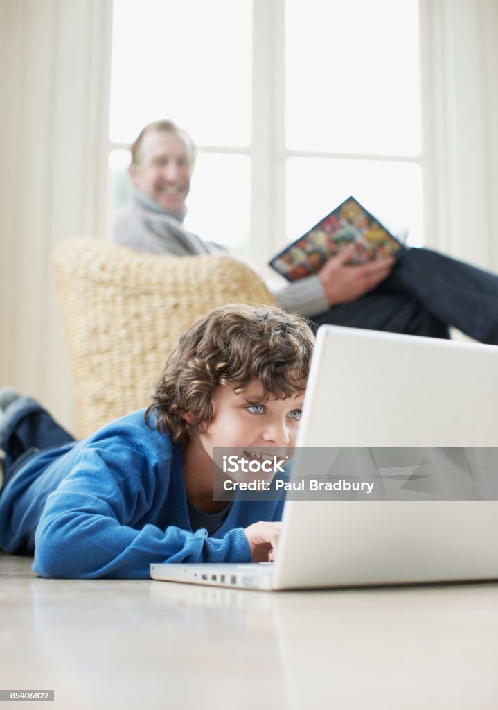 Menino deitar no chão digitando no laptop - Foto de stock de Criança royalty-free