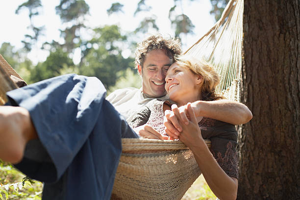 couple sitting in hammock - partnerskap bildbanksfoton och bilder