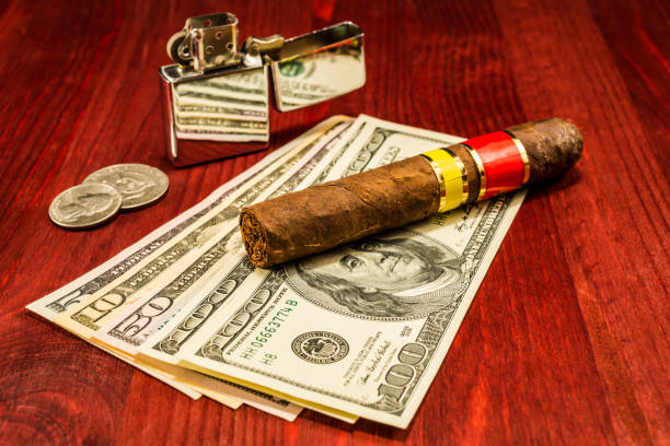 istock Cuban cigar on a several dollar bills and also coins and lighter 854074756