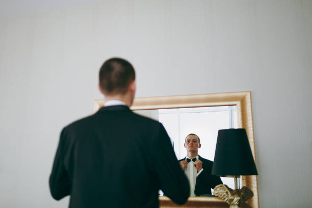 istock Groom looks in the mirror and adjusts the bow tie 854077412