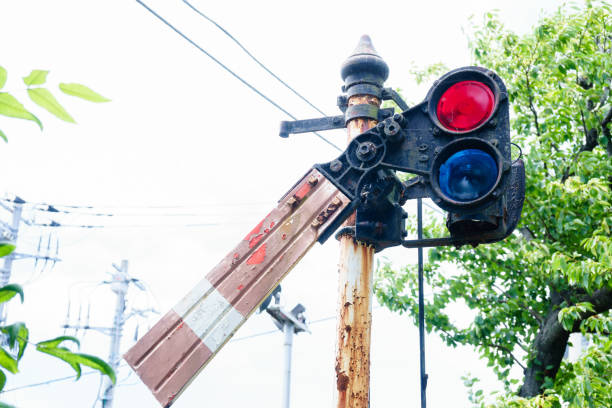 A detailed image of red light signal lamps glowing at a train station in the afternoon, showcasing essential railway safety infrastructure. The soft natural light adds contrast to the illuminated red lights, symbolizing a stop or caution signal for approaching trains. Ideal for editorial use, transportation-themed content, or articles focusing on railway systems, infrastructure, or public safety in train operations.