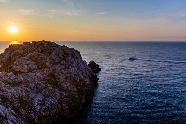 The passenger cruise ship is sailing at sunset near the beautiful Lim bay and valley (Lim Fjord) also known as Limska draga or Limska dolina, looking for dolphins.