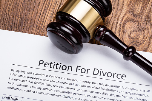 Wooden Gavel On Petition For Divorce Paper At Wooden Desk In Courtroom
