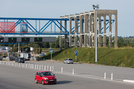 Le Havre - August 24,  2017: Toll station with passing cars at bridge Pont de Normandie over river Seine