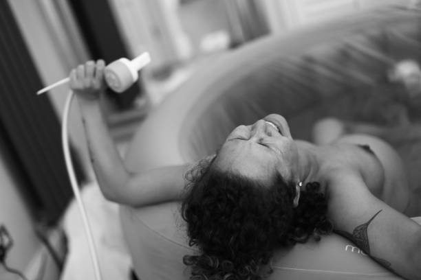 Home Birth Woman during childbirth at home water birth photos stock pictures, royalty-free photos & images