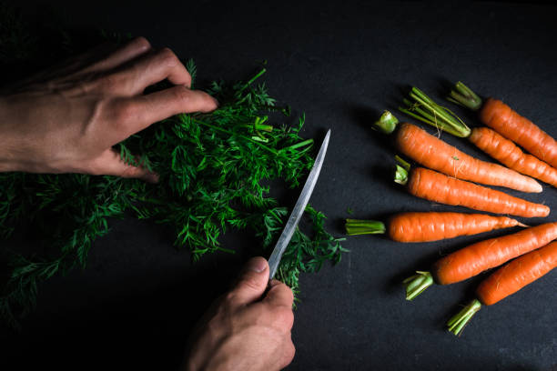 istock Cutting green carrot leaves and carrots 854109566