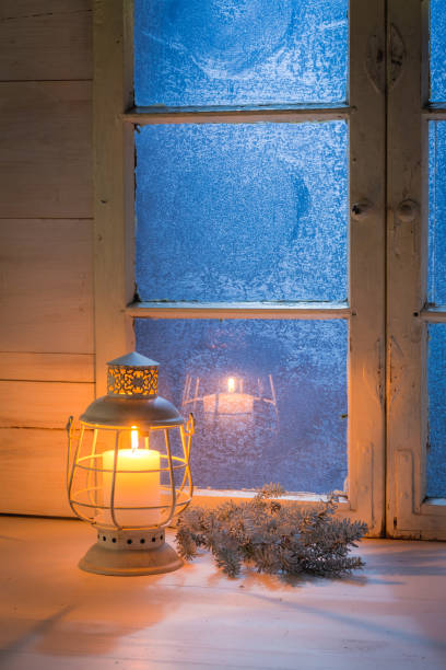 istock Frosted blue window and burning candle for Christmas 854109590