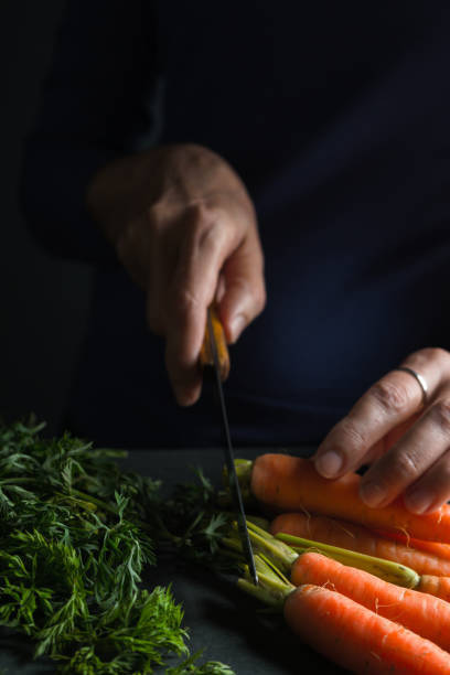 istock Crop is cut off from the carrot with a knife 854110492
