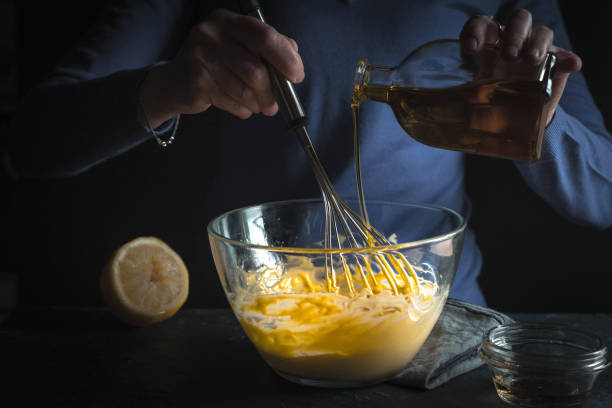 Beat egg yolks with mustard and olive oil stock photo