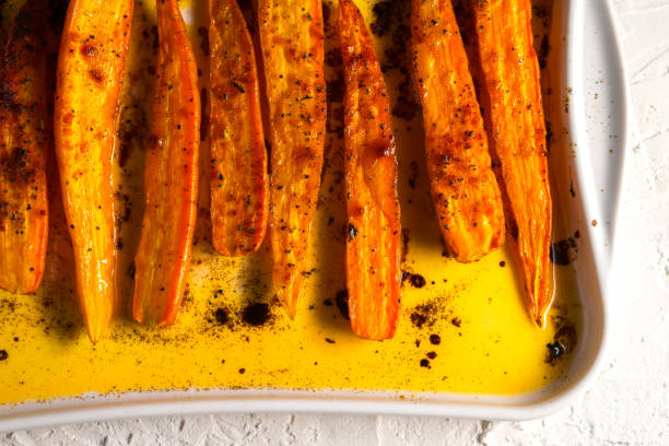 istock Orange stewed carrots in spices on a ceramic baking sheet 854130206