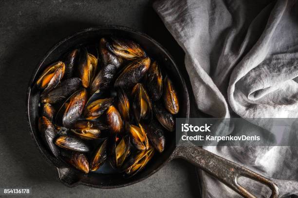 Mussels On A Castiron Frying Pan And Napkin On A Gray Background Diagonal Stock Photo - Download Image Now
